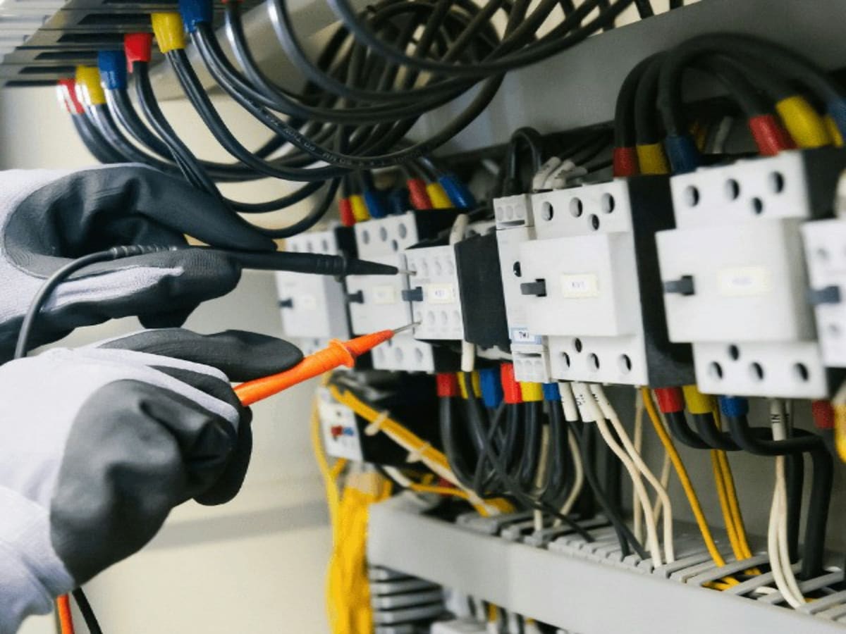 Τεχνικός με γάντια δουλεύει στους αυτόματους διακόπτες ενός ηλεκτρικού πίνακα